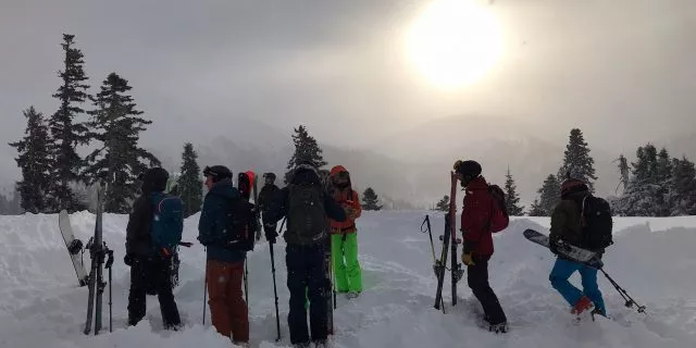 Group of cat skiing freeriders in Georgia framed against the setting sun