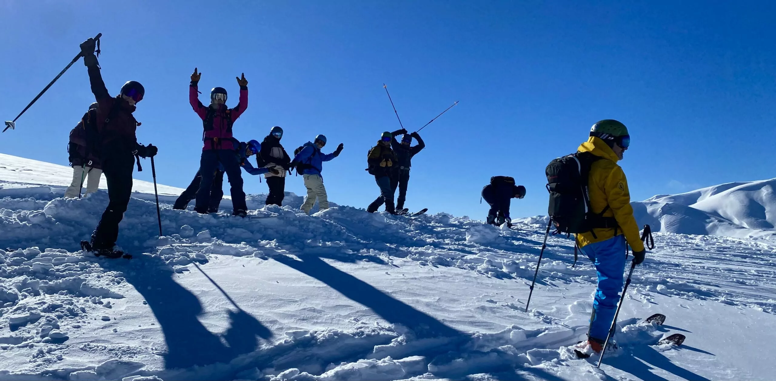 Group of cat skiers and snowboarders at the top of a backcountry run in Georgia's lesser Caucasus mountains