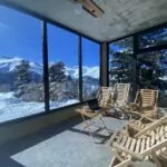 Laptop and coffee on a small table, remote working with a glass front mountain view in Georgia